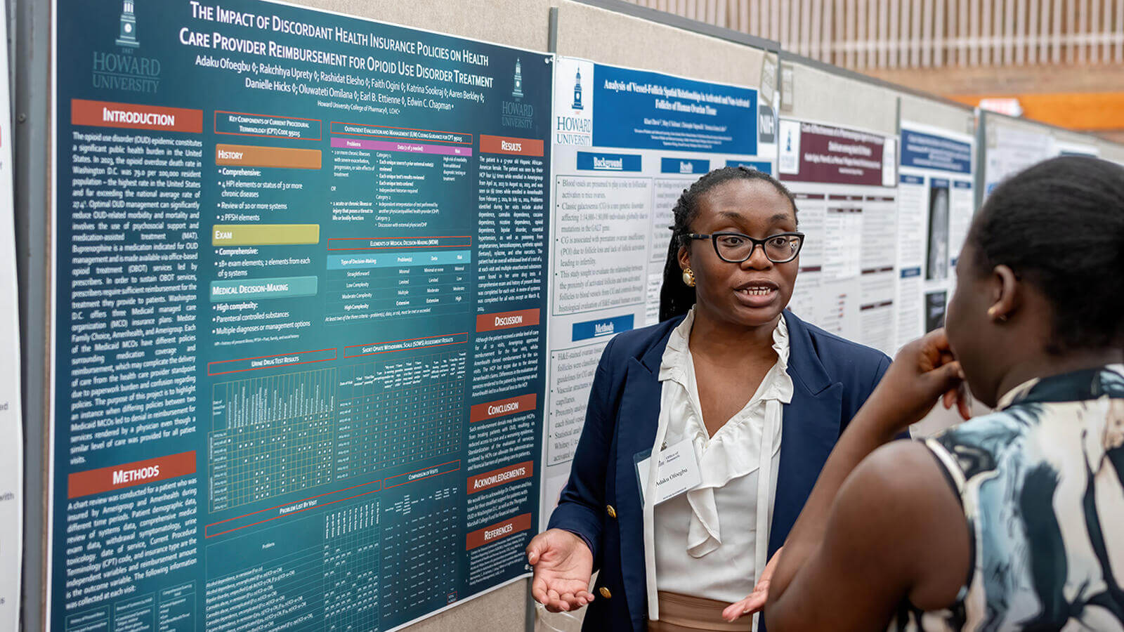 Professional explaining a presentation with data to a student at a conference