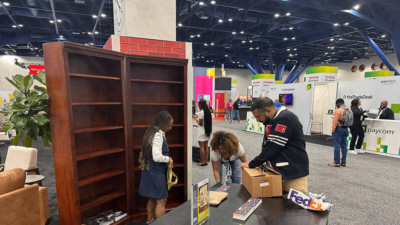 Afro Tech team setting up their conference booth, laying issues of Howard Magazine on the table