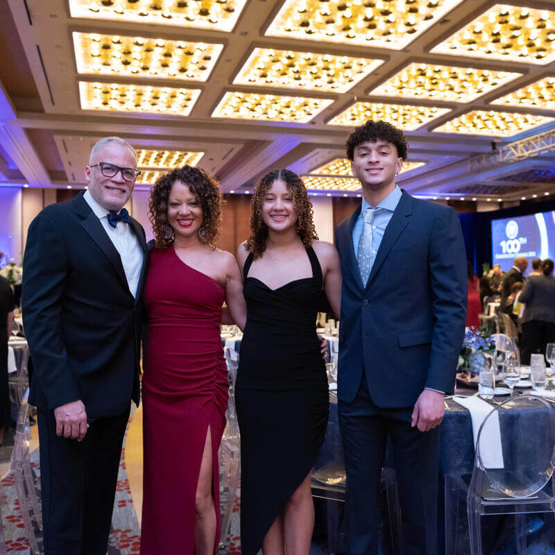 Family of 4 posing for a photo at Charter Day