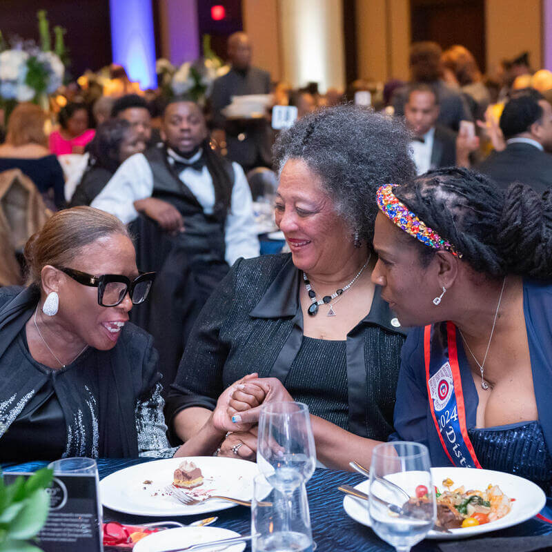 3 attendees laughing at Chater Day Dinner table
