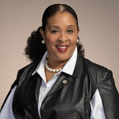 Princess Gamble smiling wearing a black jacket and white shirt.