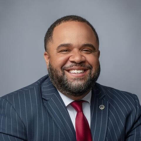 Rashad Young wearing a pinstriped blue blazer, red tie and white shirt.