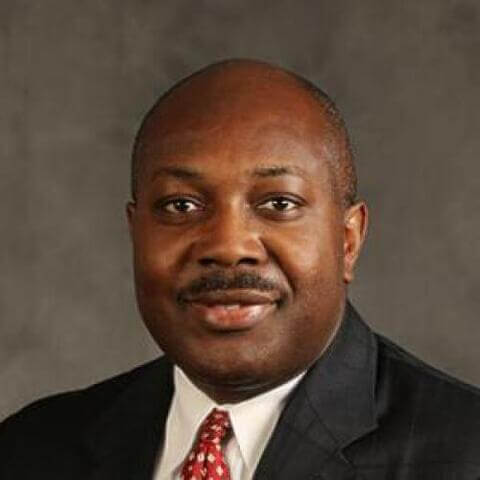 Anthony K. Wutoh, Ph.D., R.Ph. wearing a dark suit with a patterned tie and white shirt, smiling.