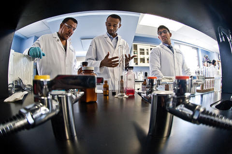 Three researchers in a lab setting.