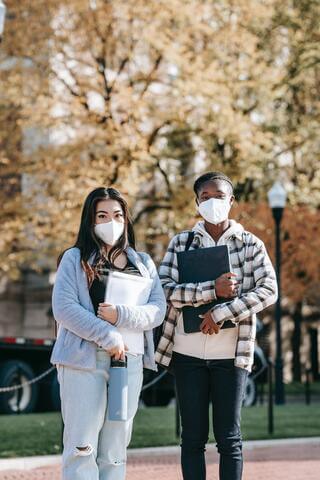 Two students in masks on a college campus.