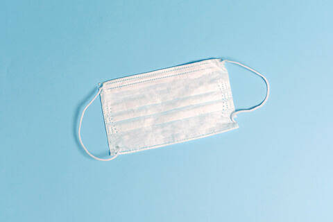 Photo of a white mask against a light blue background