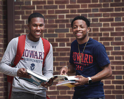 Two Howard students with a book.