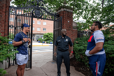 Students smiling and speaking with campus security