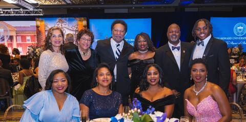 10 Charter Day guests smiling behind reception table