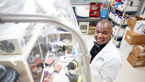 Researcher working in a lab and smiling