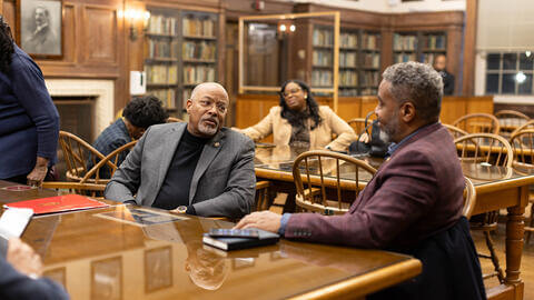 Two men talking in a Howard University library
