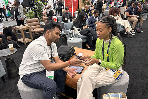 Students looking at a phone and networking at Afro Tech