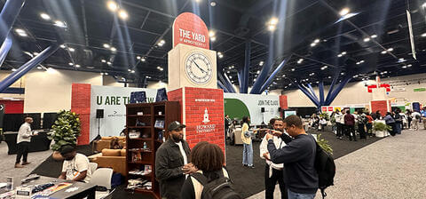 Howard Afro Tech booth with the clock tower in the background as conference attendees network